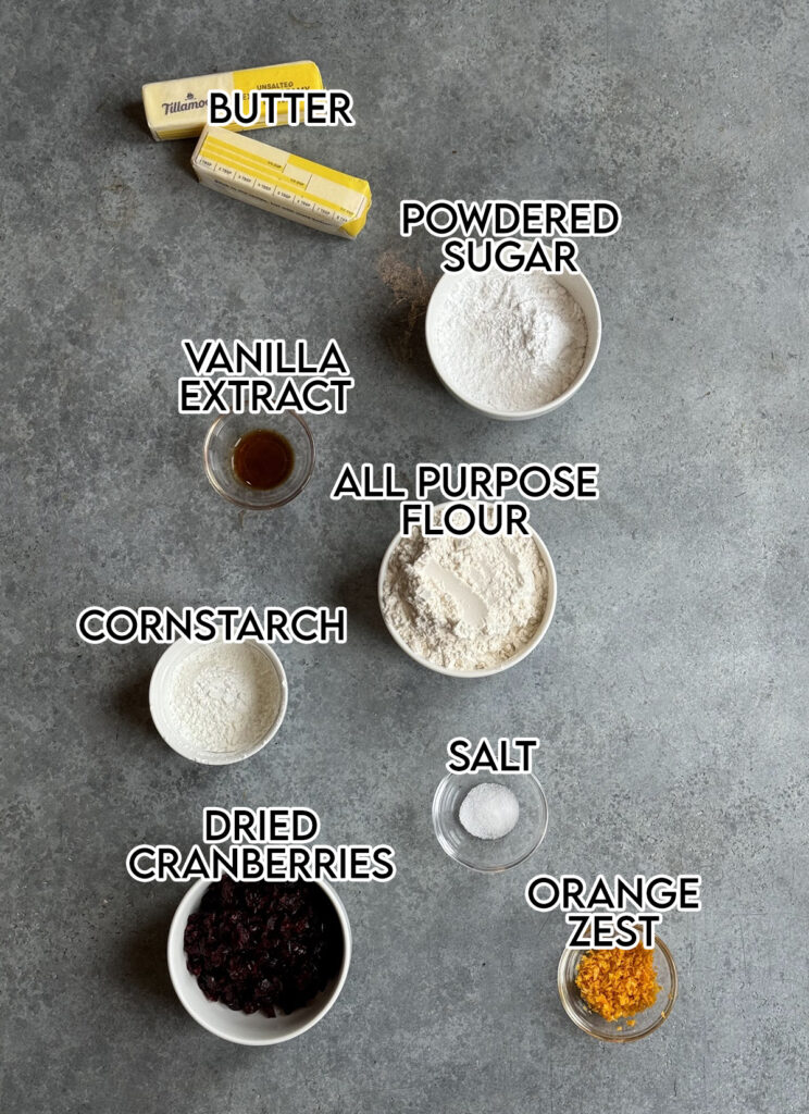 Small bowls of the ingredients needed to make cranberry orange shortbread cookies. 