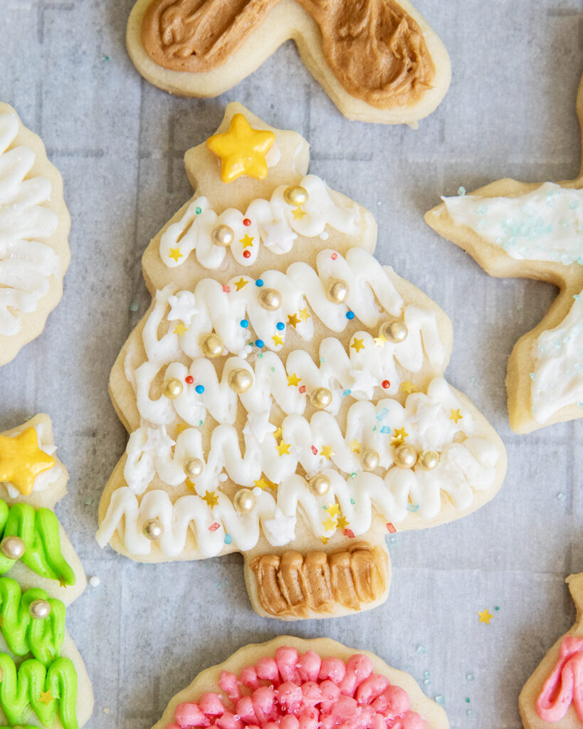 A Christmas tree frosted with white buttercream, and a brown buttercream stump. 