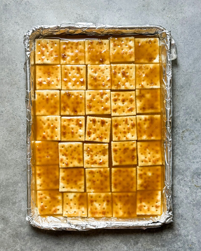 An above view of a pan of crackers with toffee poured over the top.