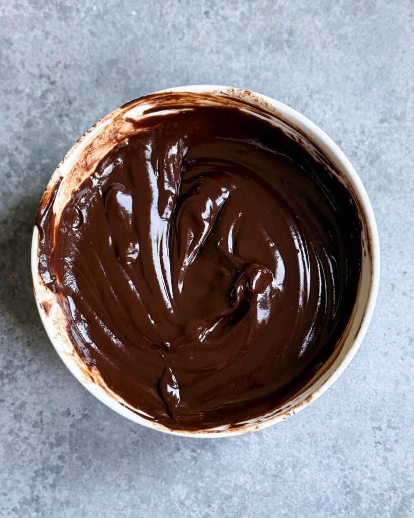 A bowl of melted chocolate ganache.