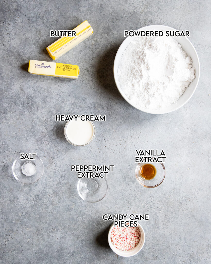 Bowls of the ingredients needed to make peppermint frosting, like powdered sugar, heavy cream, and peppermint extract. 