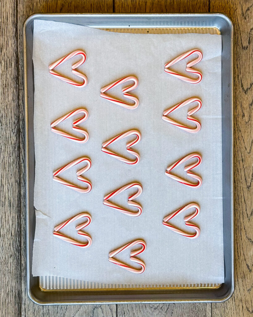 Candy canes arranged in rows on a baking pan to look like hearts.