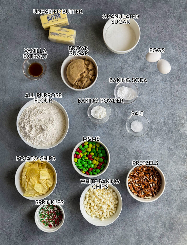 The ingredients needed to make Christmas Kitchen Sink Cookies, including butter, sugar, vanilla, eggs, flour, m&ms, and pretzels.