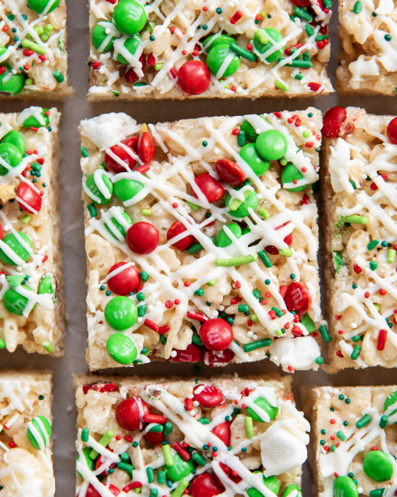 A close up of an above view of Christmas Rice Krispie Treats topped with mini m&ms and sprinkles.