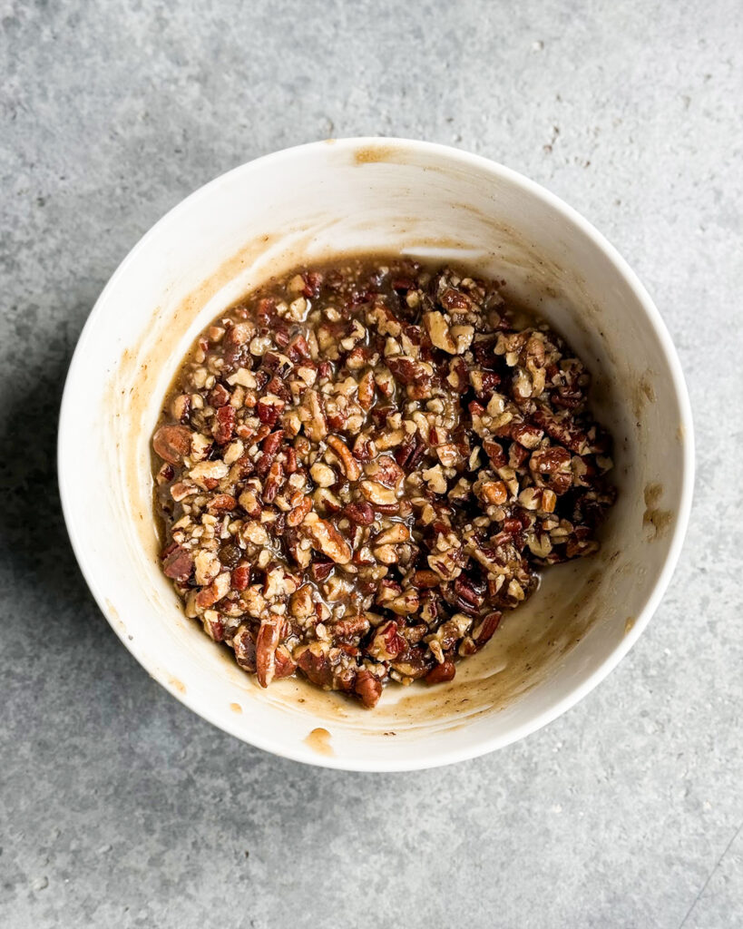 Pecan pie filling in a white bowl.