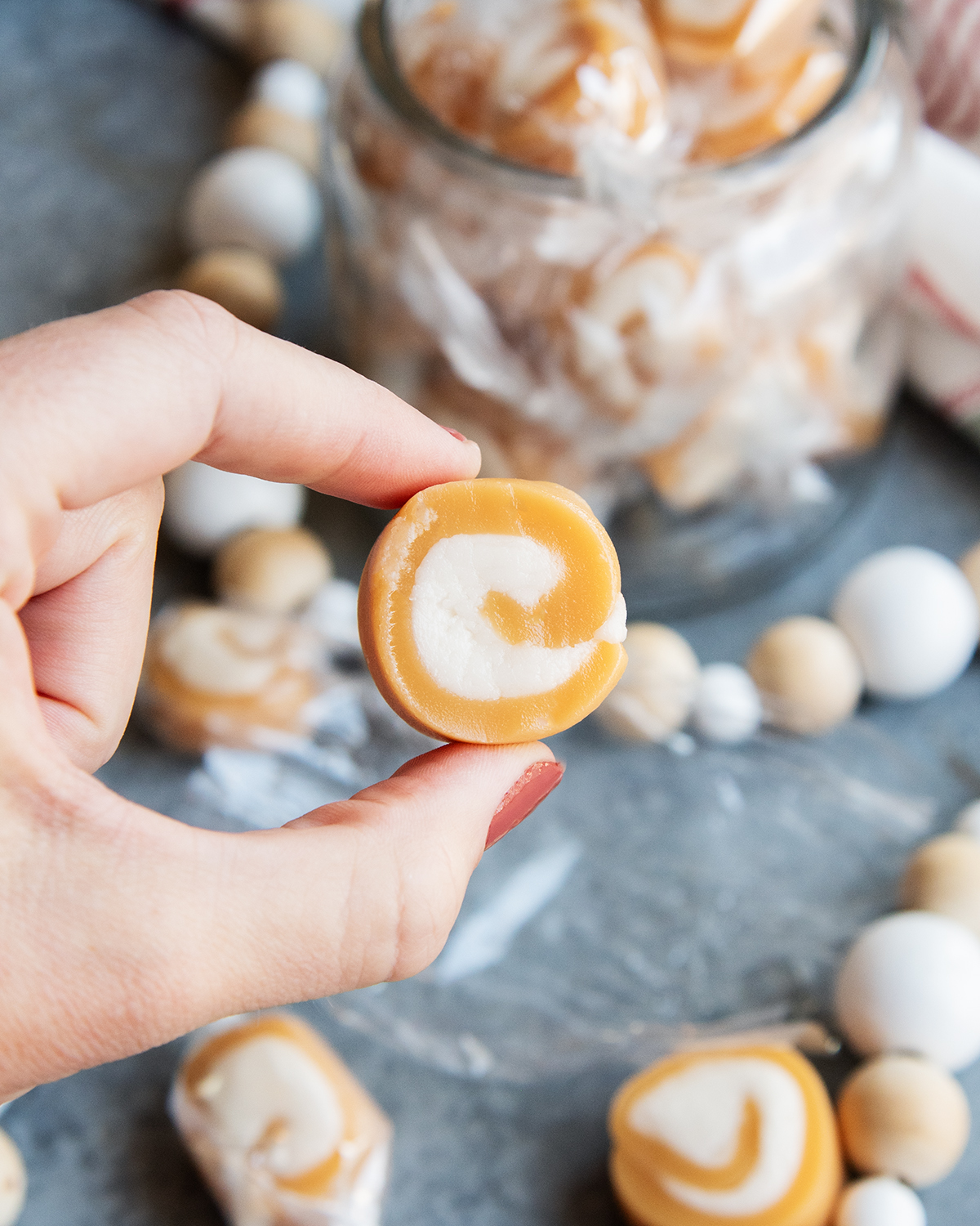 A hand holding a Vanilla Caramel Cream with vanilla swirl in the middle.