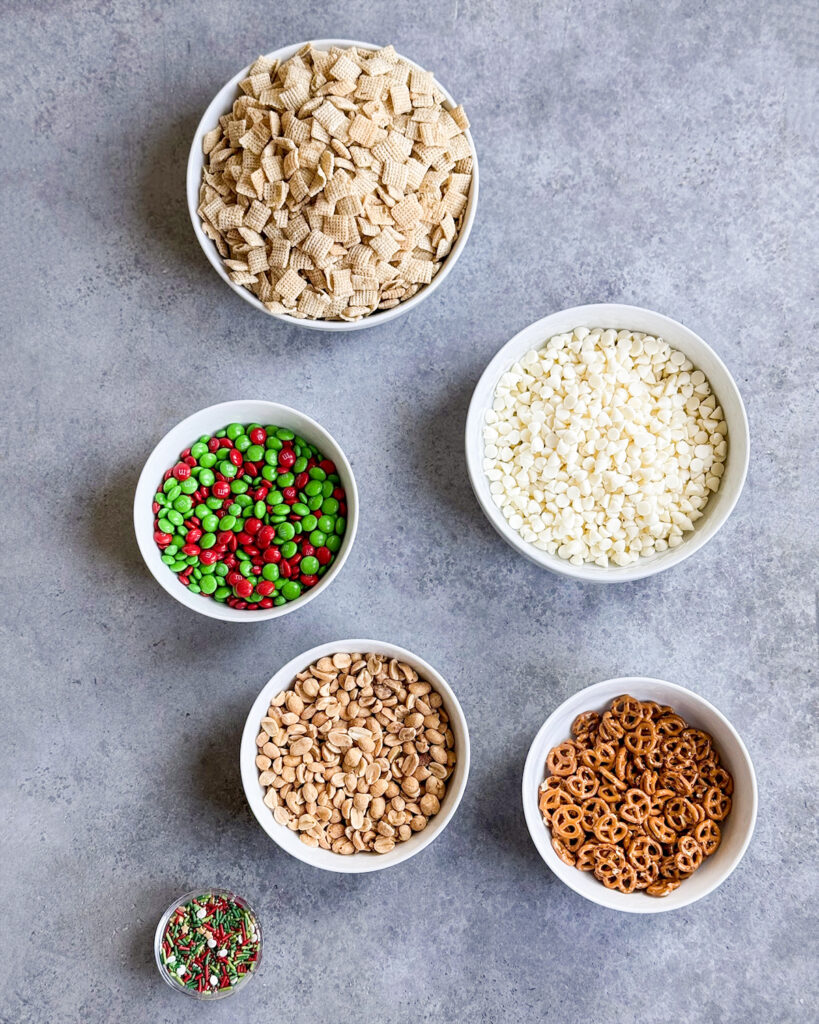 Bowls of the ingredients needed to make white trash chex mix. 