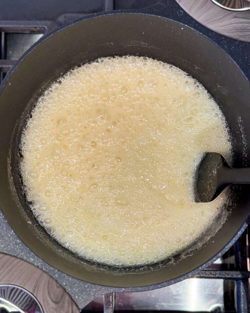 A pot of melted cooked sugar, on the process to making caramel. 