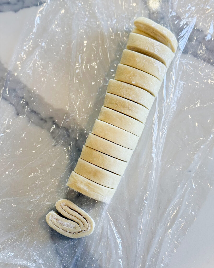 Puff Pastry rolled up for palmiers and sliced into pieces.