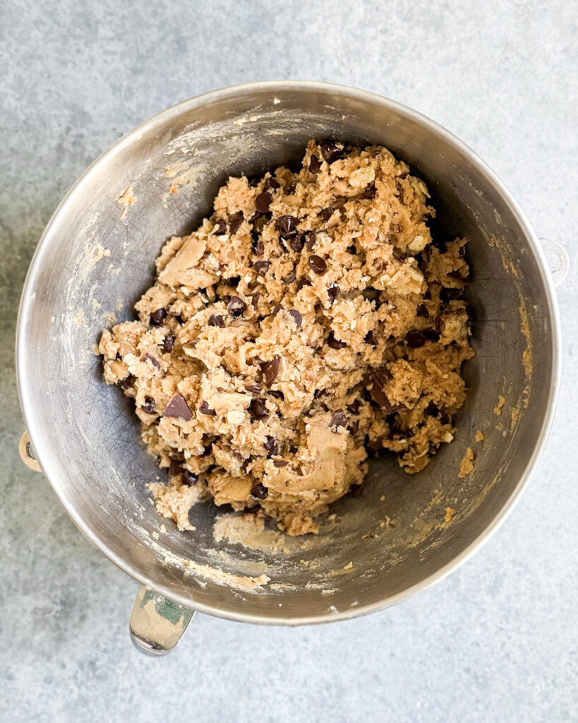 A big bowl of cookie dough with toffee pieces and chocolate chip pieces.