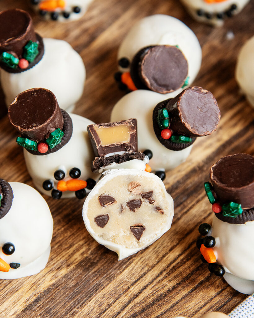 A white chocolate cookie dough ball cut in half showing the chocolate chips in the middle.