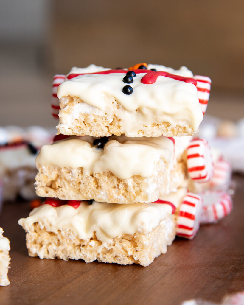 A stack of three rice krispie treats topped with white chocolate.