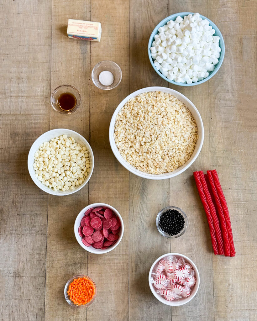 Small bowls of the ingredients needed to make Snowman Rice Krispie Treats. 