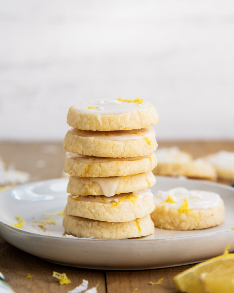 A stack of coconut lemon shortbread cookies on a white plate.