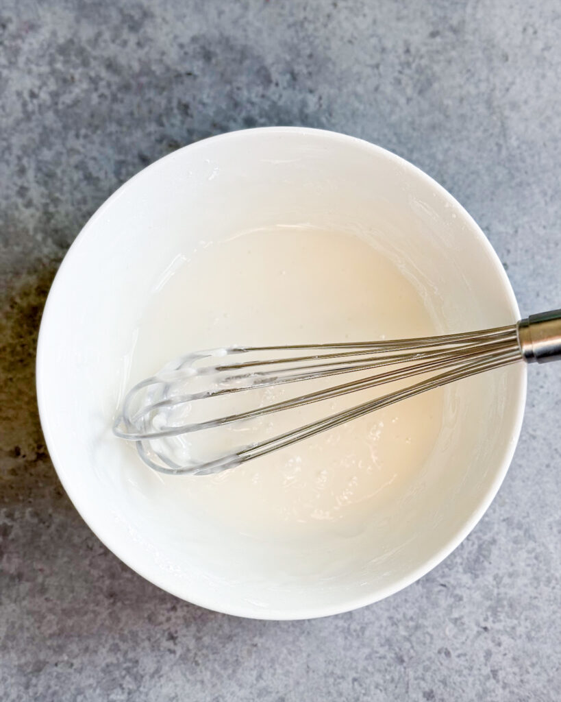 A bowl of whisked lemon glaze.