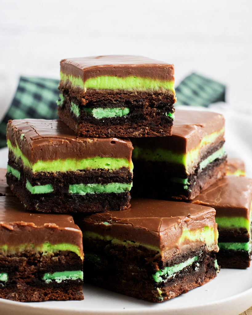 A pile of mint Oreo brownies on a piece of parchment paper.