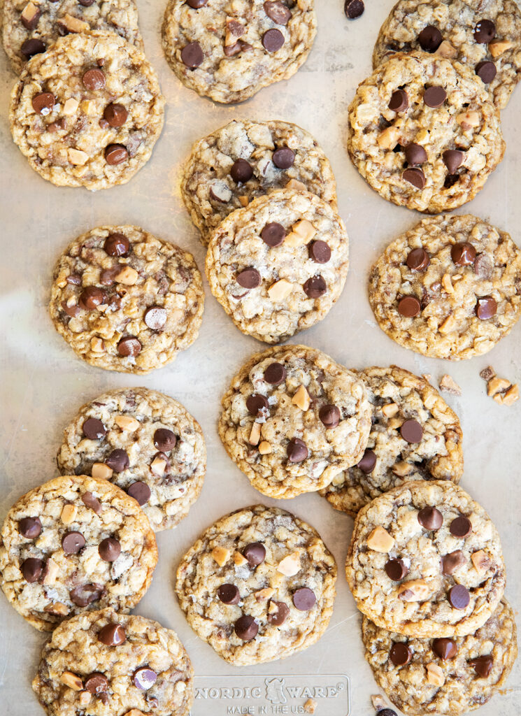 An above view of a cookie sheet topped with oatmeal toffee and chocolate chip cookies.