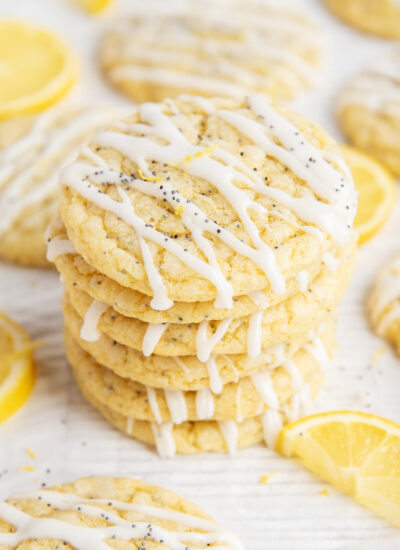 A stack of lemon poppyseed cookies with lemon icing drizzled on them.