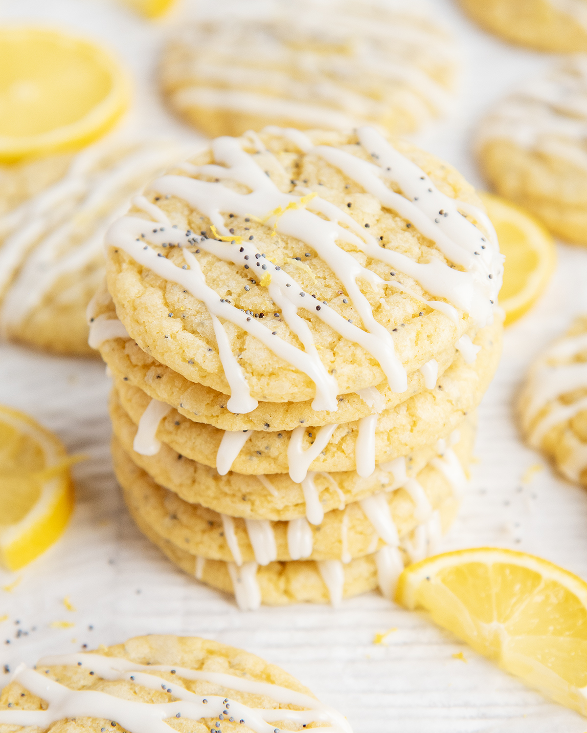 A stack of lemon poppyseed cookies with lemon icing drizzled on them.