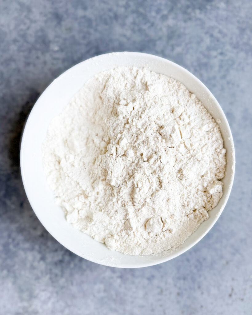 A bowl of flour, mixed with salt and baking powder.