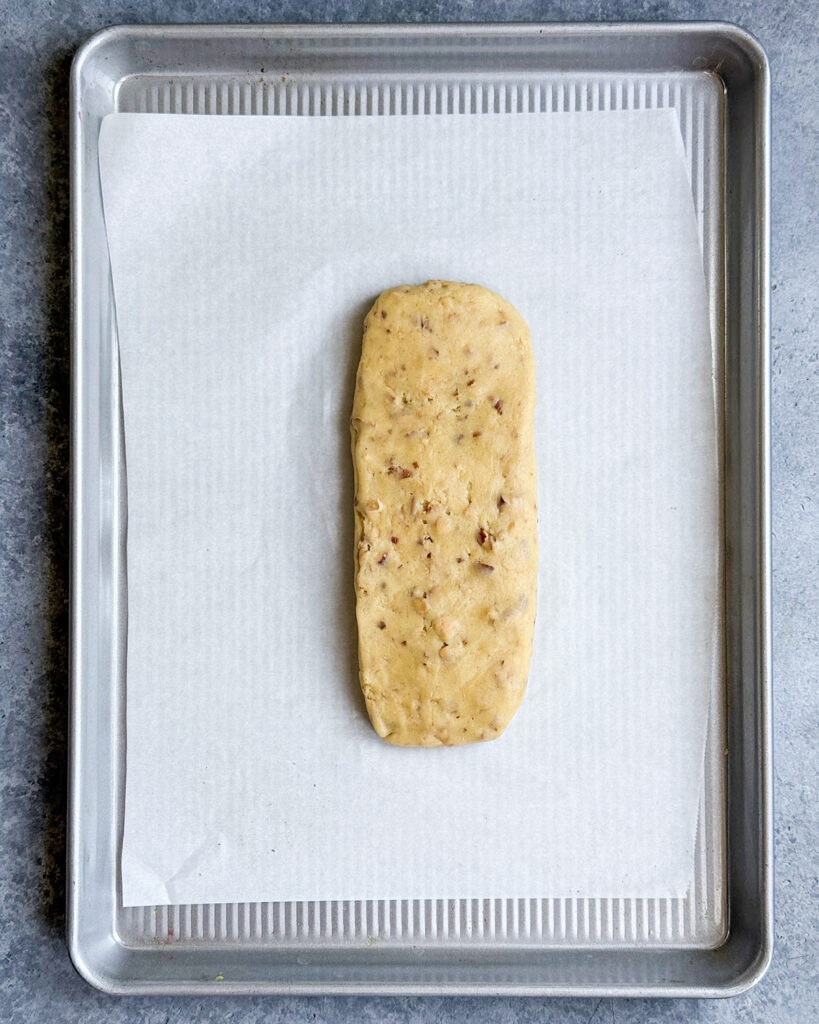 A loaf of almond biscotti dough on a baking pan.