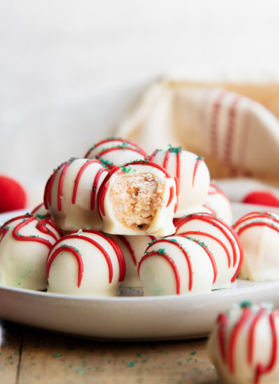 A plate of Little Christmas Tree Cake Balls in a pile, and one has a bite out of it.