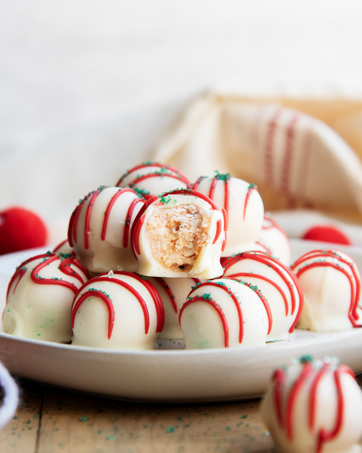 A plate of Little Christmas Tree Cake Balls in a pile, and one has a bite out of it.
