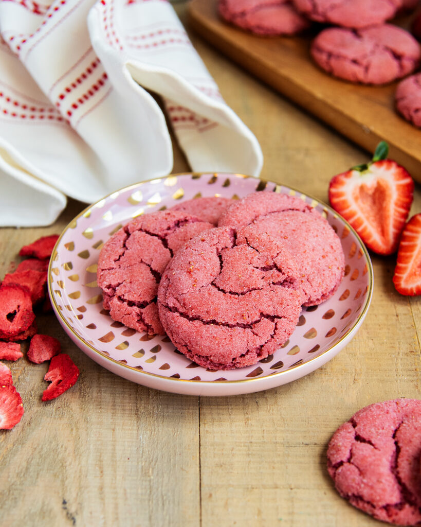 A plate of pink crinkle sugar cookies on a pink plate.
