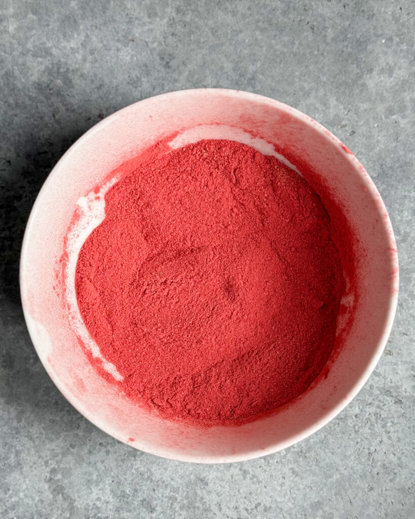 A bowl of the powder from pulverized freeze dried strawberries.