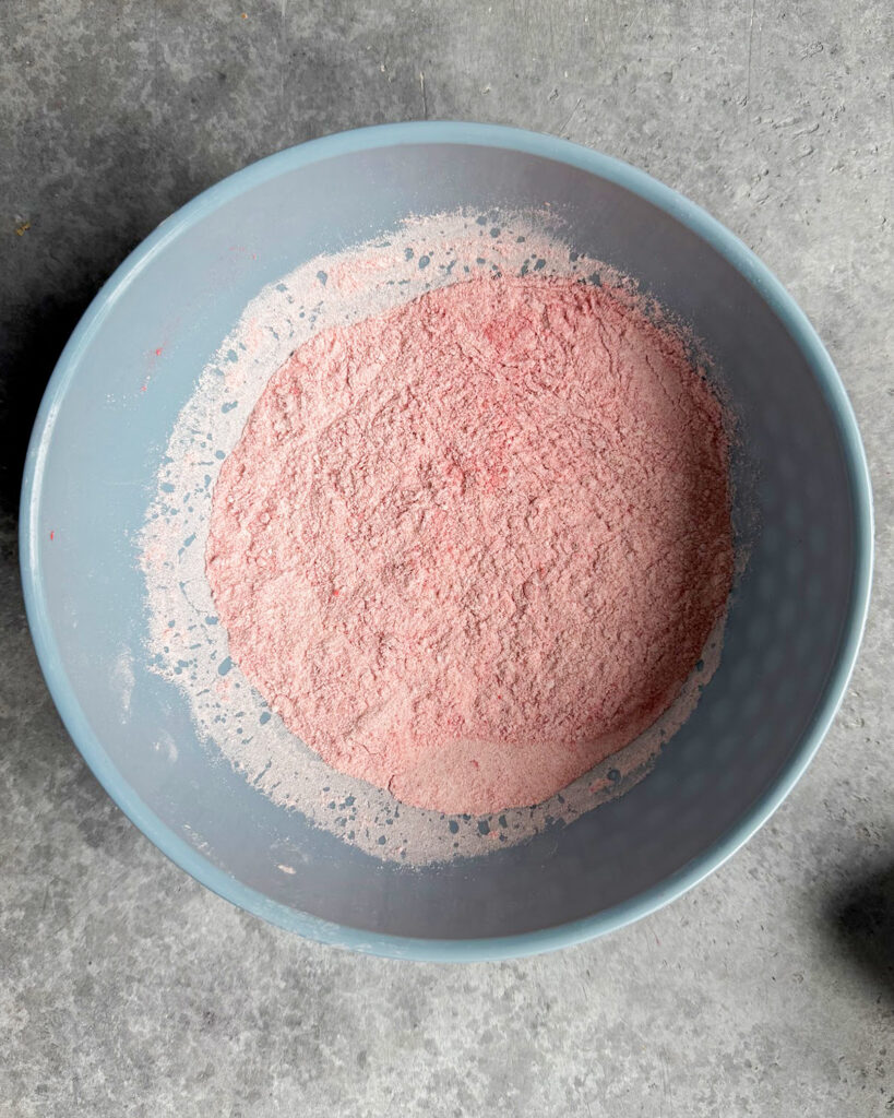 A bowl of flour, salt, baking powder, baking soda, and freeze dried strawberry powder.