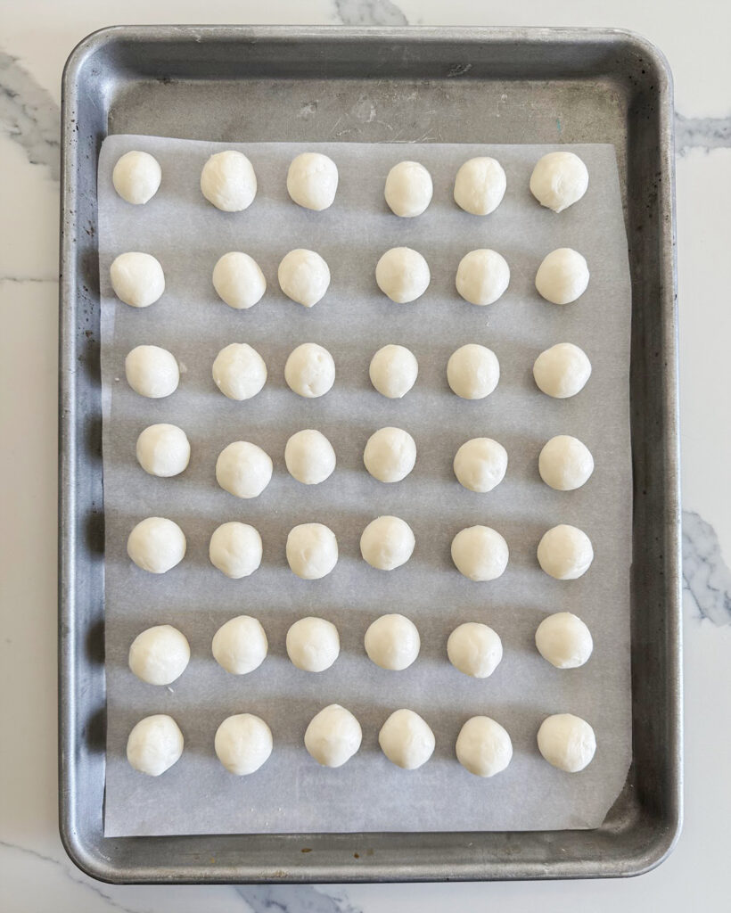 Round balls of buttercream candy on a baking sheet.