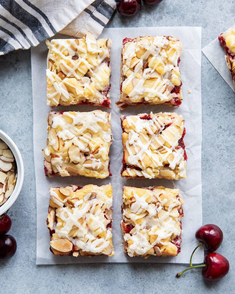 An above view of cherry almond bars with an almond glaze drizzled over the top.
