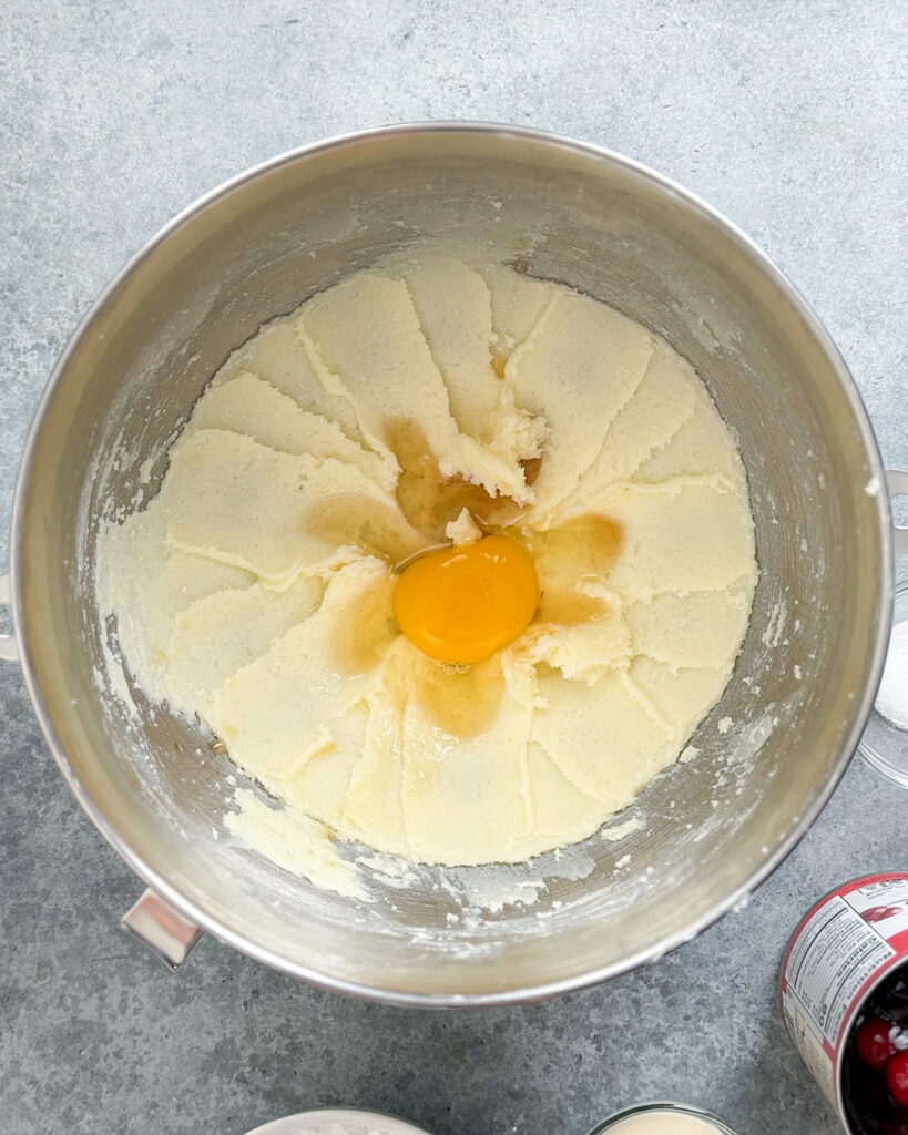 A bowl of creamed butter and sugar topped with an egg.