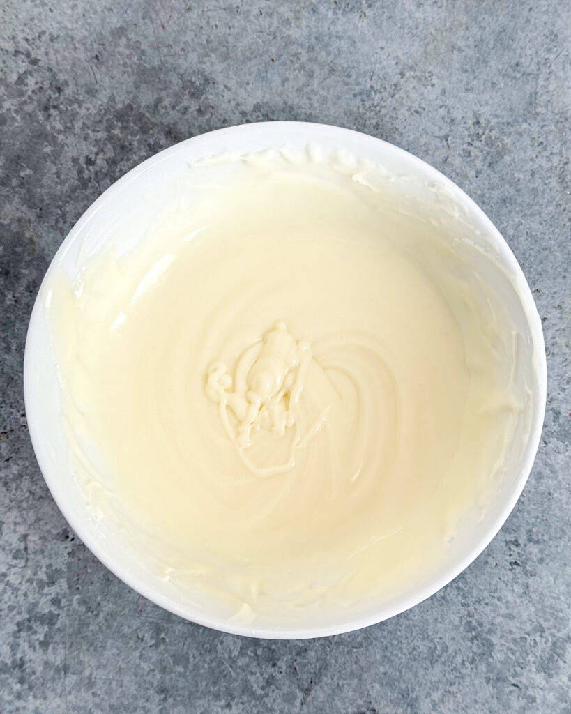 A bowl of powdered sugar and almond extract glaze.