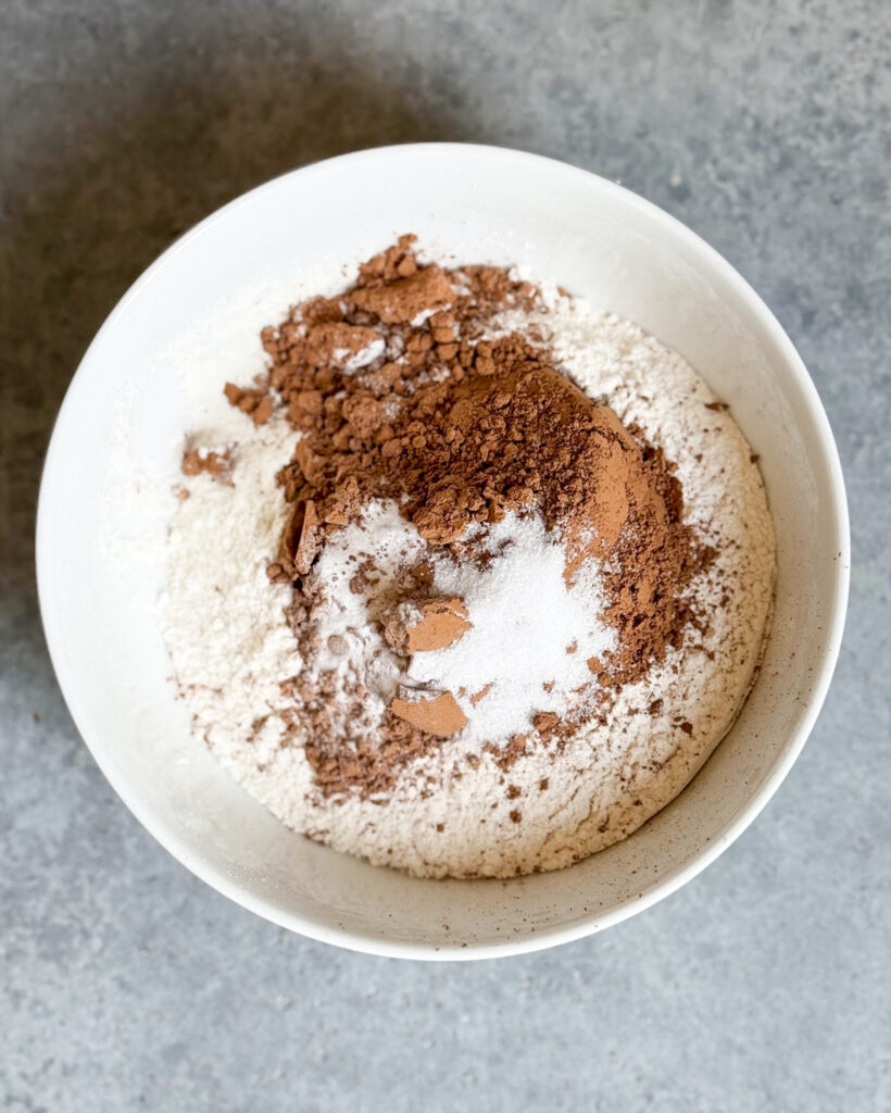 The dry ingredients for chocolate cookies in a bowl, flour, cocoa powder, baking soda, and salt.