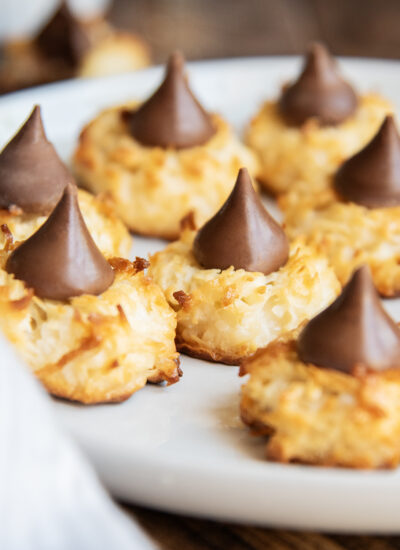 A plate of coconut macaroon cookies topped with hershey kisses.