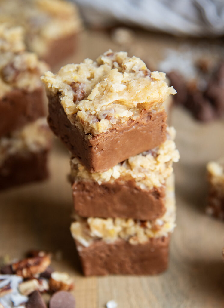 A stack of three pieces of fudge topped with German chocolate frosting.