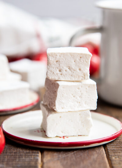 A stack of three square marshmallows on a plate.
