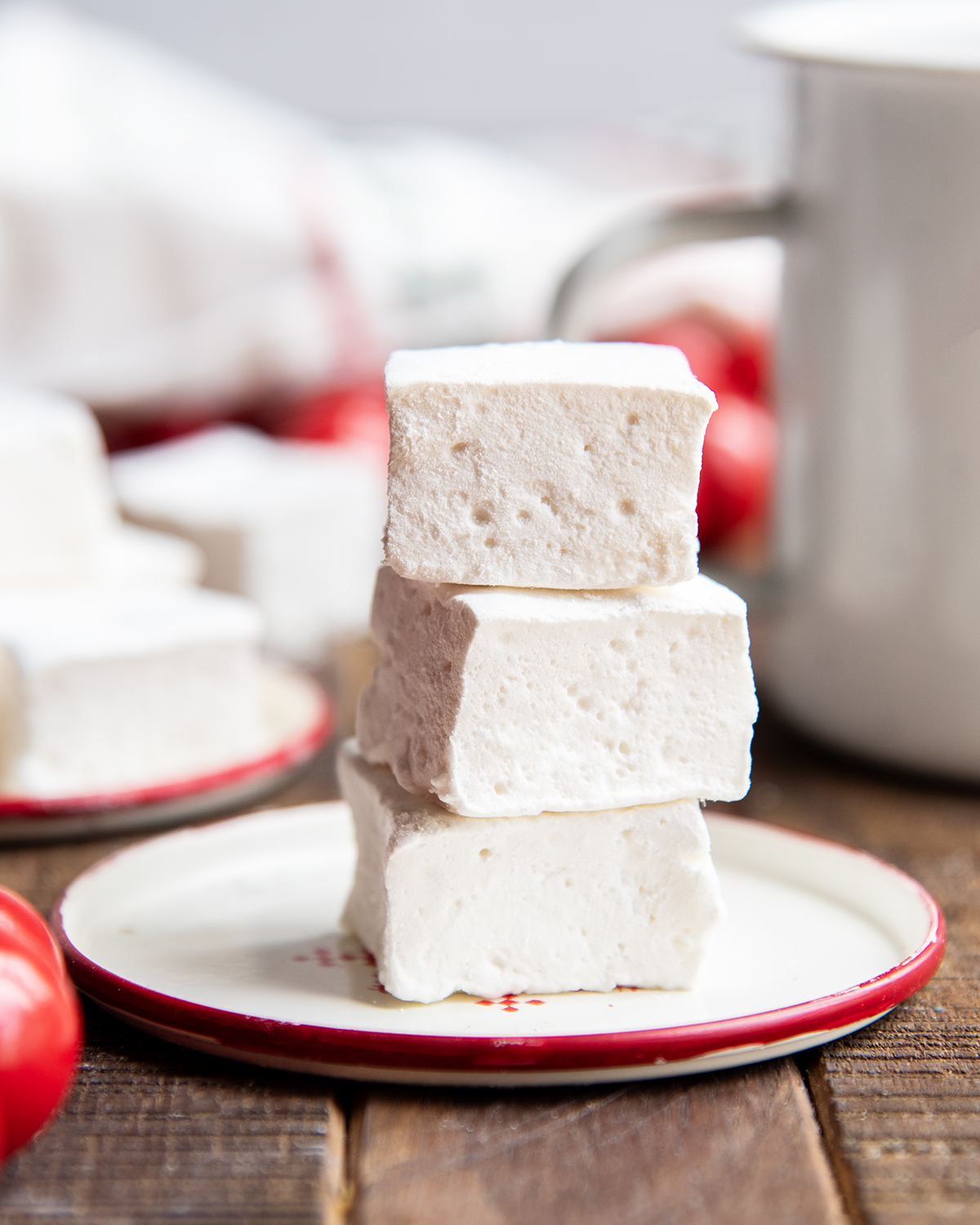 A stack of three square marshmallows on a plate.