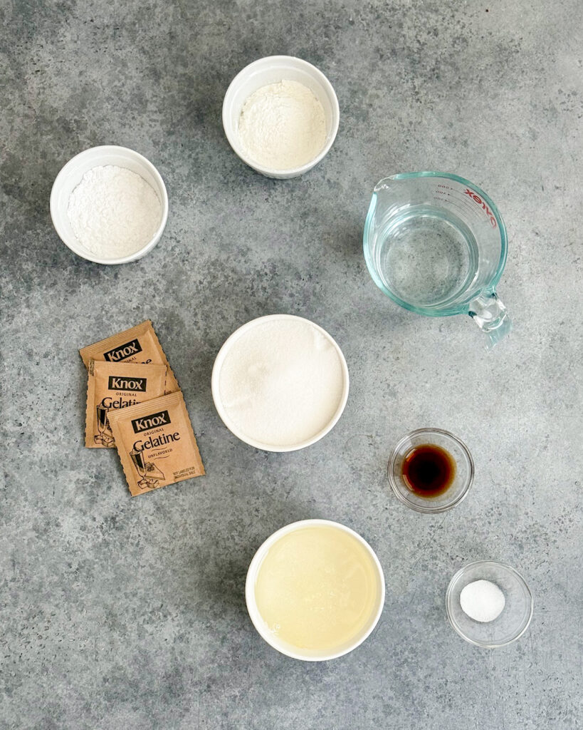The ingredients needed to make homemade marshmallows, including gelatin, sugar, corn syrup, vanilla, and water.