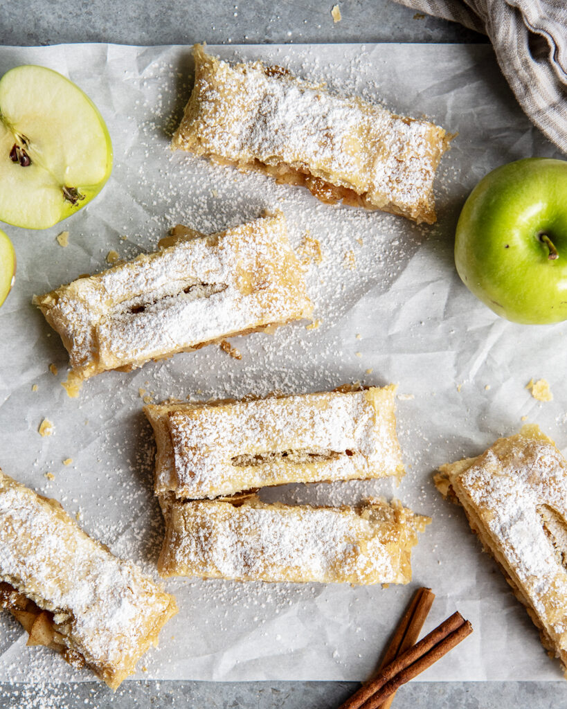 An above view of slices of apple strudel topped with powdered sugar.