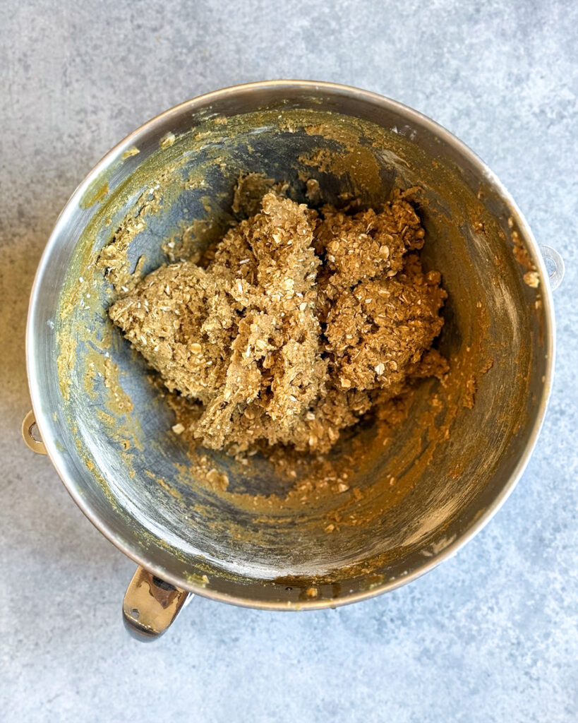Gingerbread oatmeal cookie dough in a metal bowl.