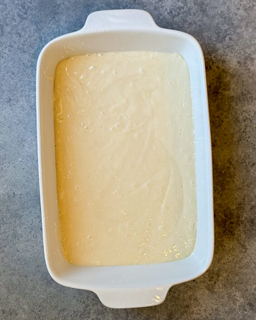 Unbaked cake batter in a white rectangle dish.