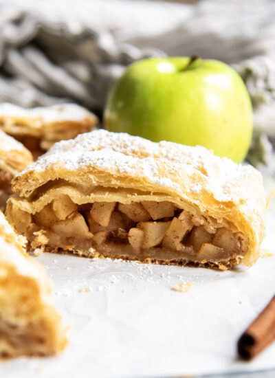 A slice of Austrian Apple Strudel on a piece of parchment paper.
