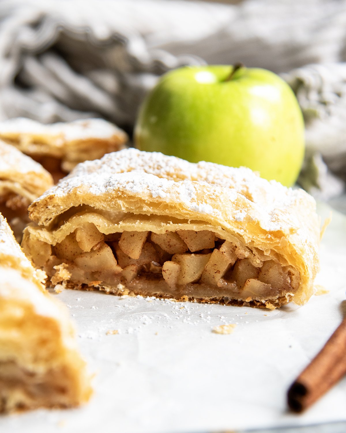 A slice of Austrian Apple Strudel on a piece of parchment paper.