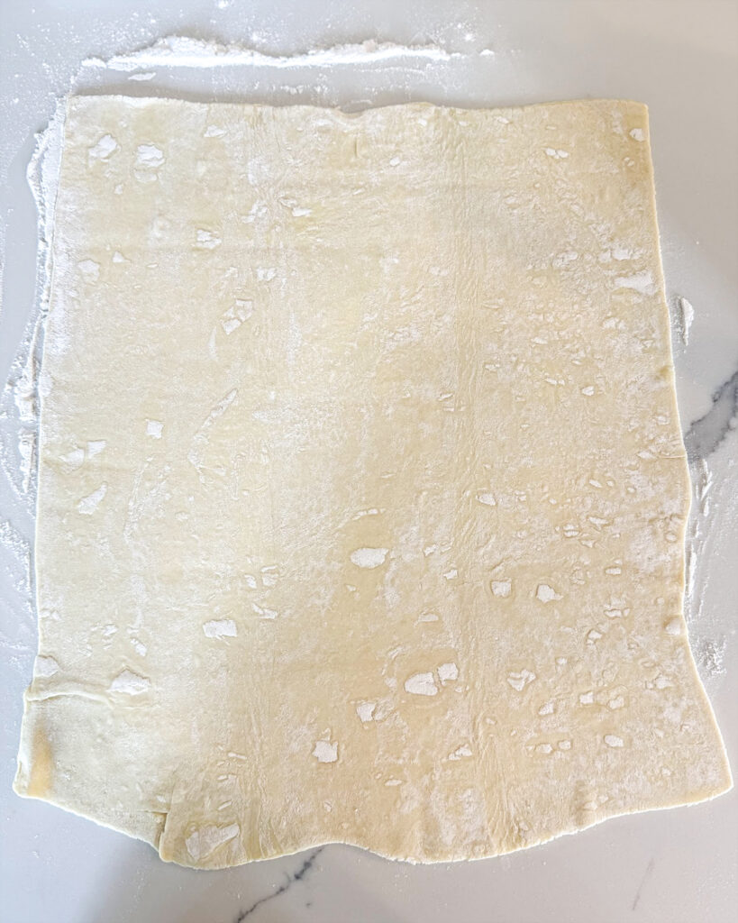 Rolled out puff pastry on the counter top.