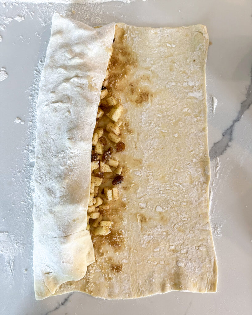 Puff pastry filled withe diced apples and golden raisins, with it folded over the top.