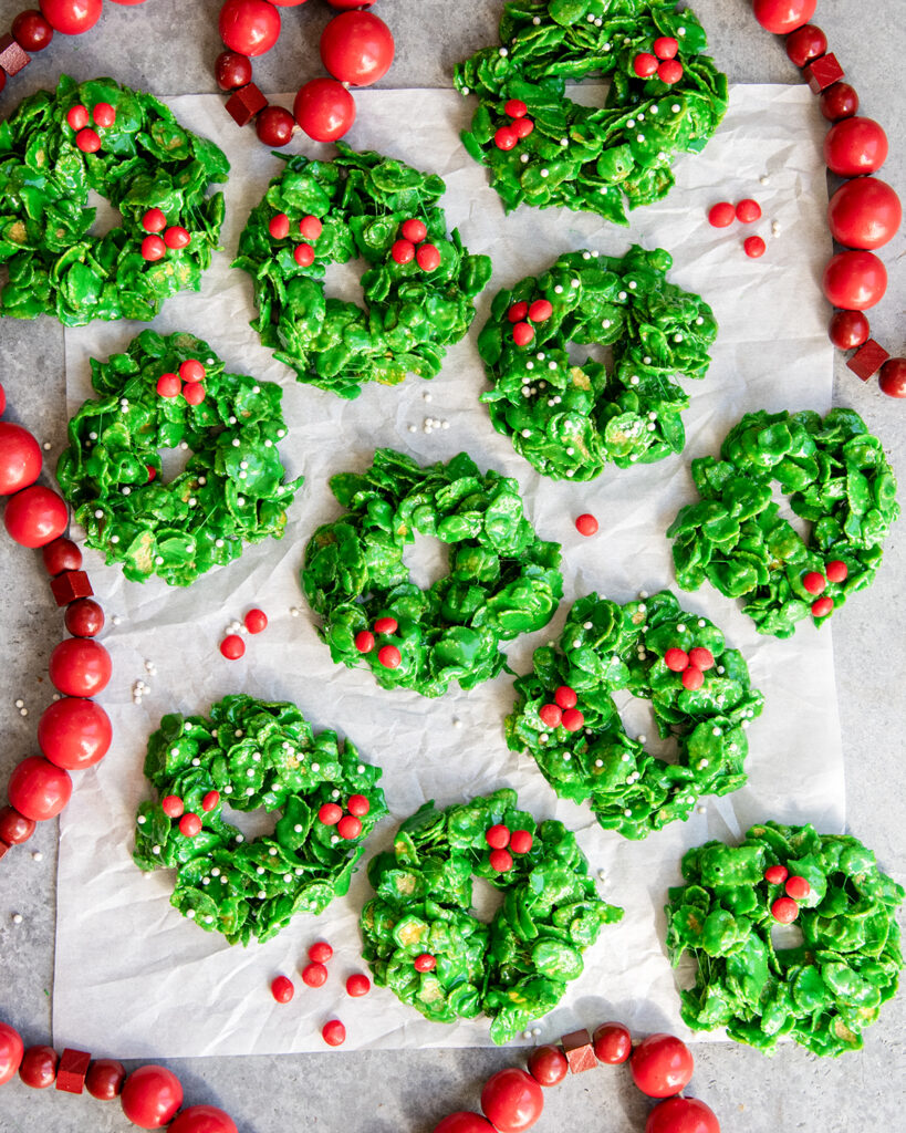 An above view of of Christmas Cornflake Wreath Cookies, topped with red candies to look like holly berries.