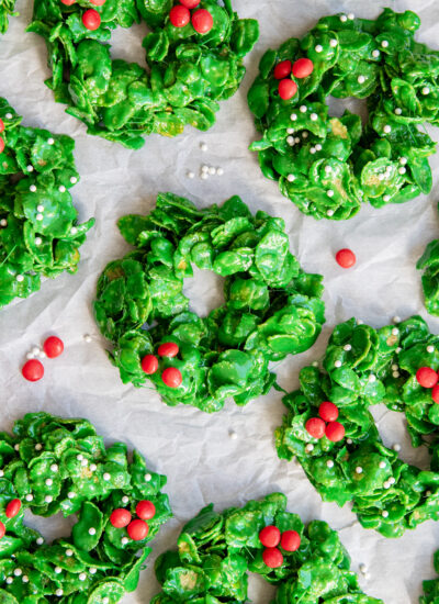 An above view of of Christmas Cornflake Wreath Cookies, topped with red candies to look like holly berries.