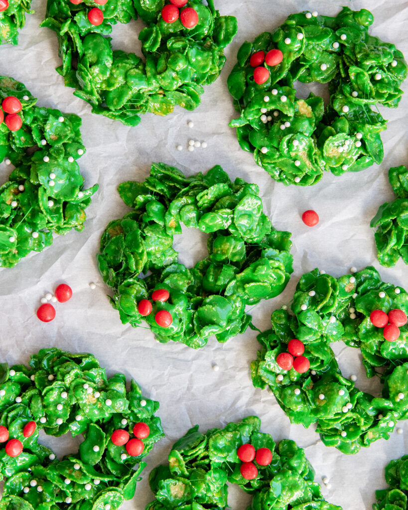 An above view of of Christmas Cornflake Wreath Cookies, topped with red candies to look like holly berries. 